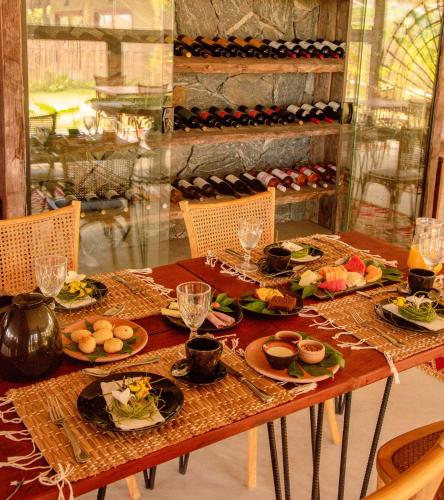 a wooden table with plates of food on it at Pousada Haya in São Miguel dos Milagres