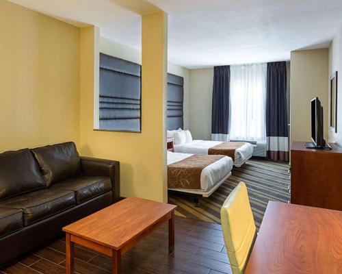 a hotel room with two beds and a couch at Comfort Suites near Tanger Outlet Mall in Gonzales