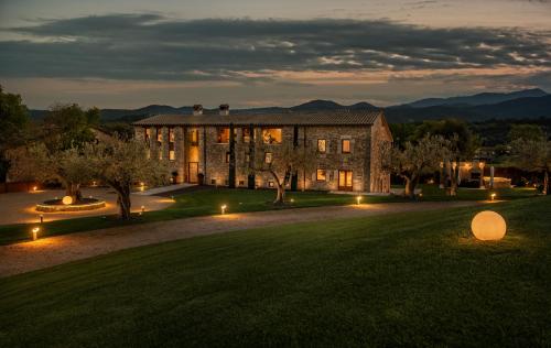un gran edificio con luces en el césped por la noche en Mas Rosset - Luxury Villa Girona - Costa Brava, en Cornellá de Terri
