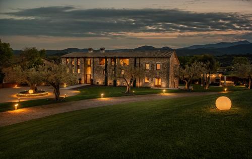 Cornellá de TerriにあるMas Rosset - Luxury Villa Girona - Costa Bravaの夜の芝生の灯りを持つ大きな建物