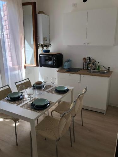 a kitchen with a table and chairs with plates and wine glasses at Casa Mestrina in Mestre