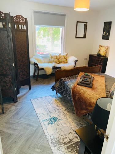 a living room with a bed and a window at Funky cozy cottage with outside space in Eastbourne