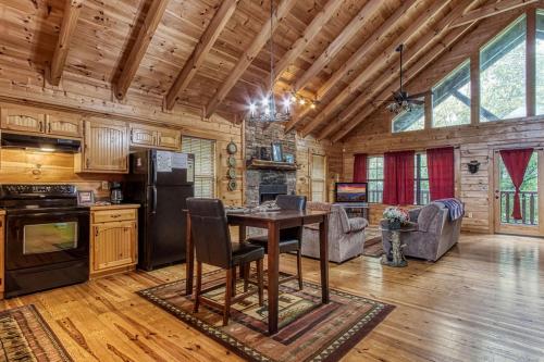 a kitchen and living room with a table in a cabin at Always Kiss Me Goodnight-Hot Tub, Arcade, Near the Parkway! in Pigeon Forge