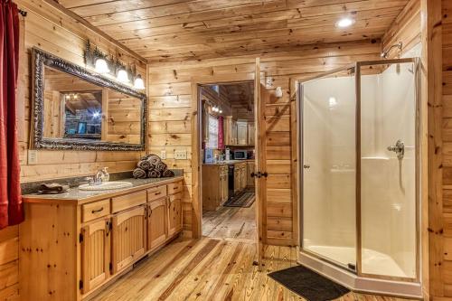 a bathroom with a shower and a sink at Always Kiss Me Goodnight-Hot Tub, Arcade, Near the Parkway! in Pigeon Forge