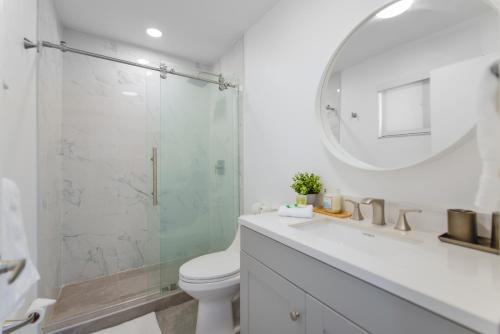 uma casa de banho com um WC e uma cabina de duche em vidro. em Awesome 4 Bedroom HouseW/Pool @Westchester Miami em Tamiami
