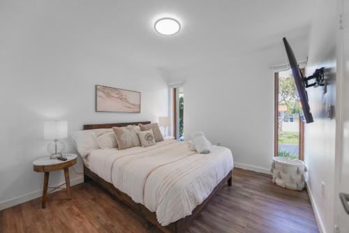 een witte slaapkamer met een bed en een raam bij Awesome 4 Bedroom HouseW/Pool @Westchester Miami in Tamiami