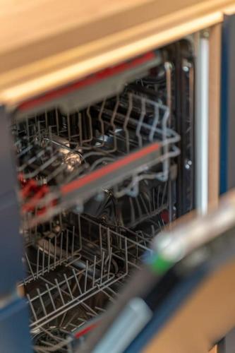 an open dishwasher with some dishes in it at Residence Koubek - Útulný apartmán s výhledem a parkováním in Špindlerův Mlýn
