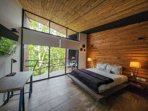 een slaapkamer met een groot bed en een groot raam bij HOTEL MADEIRA BOUTIQUE in Doradal
