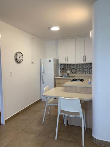 uma cozinha com uma mesa e cadeiras e um frigorífico em Dali Suites em Tijuana
