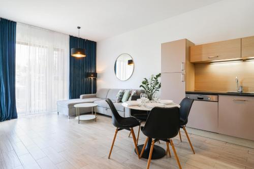 eine Küche und ein Wohnzimmer mit einem Tisch und Stühlen in der Unterkunft Baltic Park 314 in Świnoujście