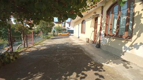 pusta ulica z budynkiem i drzewem w obiekcie Appartamento Kiwy w mieście Arsago Seprio