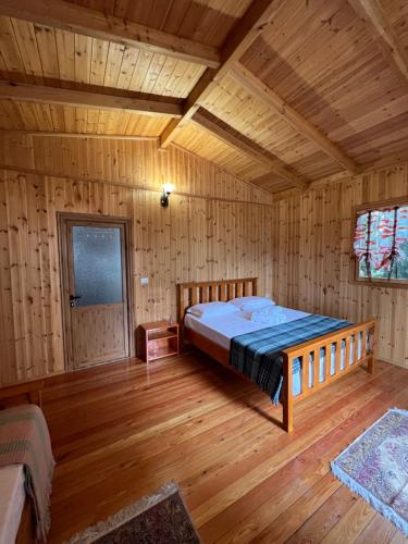a bedroom with a bed in a wooden cabin at Blen Grand in Berat
