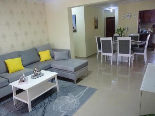 ein Wohnzimmer mit einem Sofa und einem Tisch in der Unterkunft Apartamento luminoso, espacioso y funcional, como en casa in El Seis