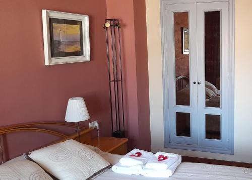 a bedroom with a bed with two towels on it at EL BALCÖN DE AVILÉS, acogedor con garaje en centro histórico, in Avilés