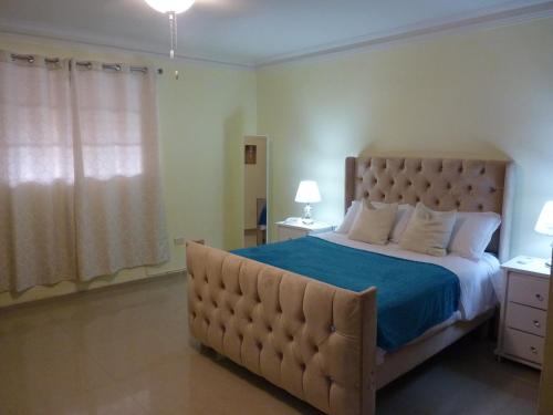 ein Schlafzimmer mit einem großen Bett mit einer blauen Decke in der Unterkunft Apartamento luminoso, espacioso y funcional, como en casa in El Seis