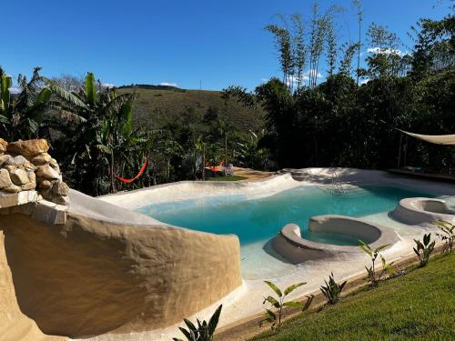 a swimming pool with a slide in a backyard at Bioevoluir in Igaratá