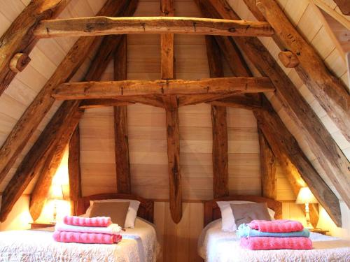 2 camas en el ático de una casa de madera en Tour Milou, en Beynac-et-Cazenac