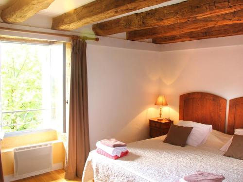 Un dormitorio con una cama y una ventana grande en Tour Milou, en Beynac-et-Cazenac