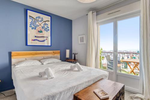 une chambre avec un grand lit et une grande fenêtre dans l'établissement Appartement Ayres - Welkeys, à Nice