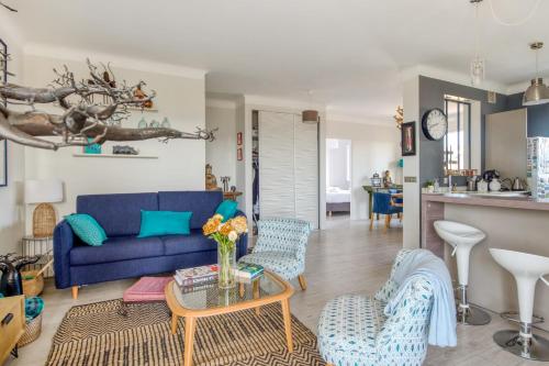 un salon avec un canapé bleu et des chaises dans l'établissement Appartement Ayres - Welkeys, à Nice
