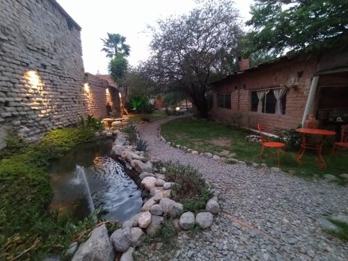 un arroyo en un patio al lado de un edificio en Casa Arbol Domos en Cafayate