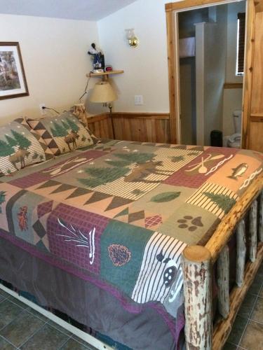 a bedroom with a bed with a colorful comforter at Lolo Hot Springs in Lolo Hot Springs