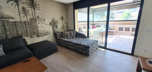 a living room with a couch and a chair in a room at Appartement luxe Taghazout bay - mer & piscine in Agadir