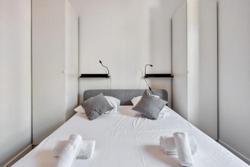 - une chambre avec un grand lit blanc et des miroirs dans l'établissement Appartement Oscarmony - Welkeys, à Nice