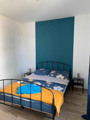 a bedroom with a bed with a blue accent wall at Porto Bianco III in Rumia