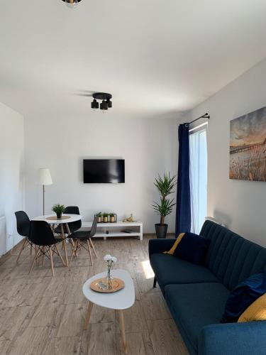 sala de estar con sofá azul y mesa en Porto Bianco III, en Rumia