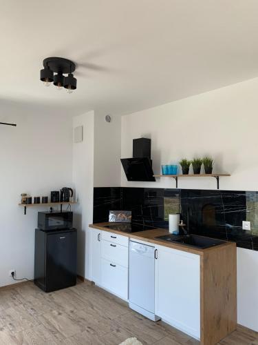 a kitchen with white cabinets and a black refrigerator at Porto Bianco III in Rumia