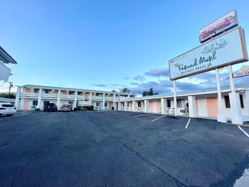 un parcheggio vuoto di fronte a un motel di The Postcard Motel a Seligman