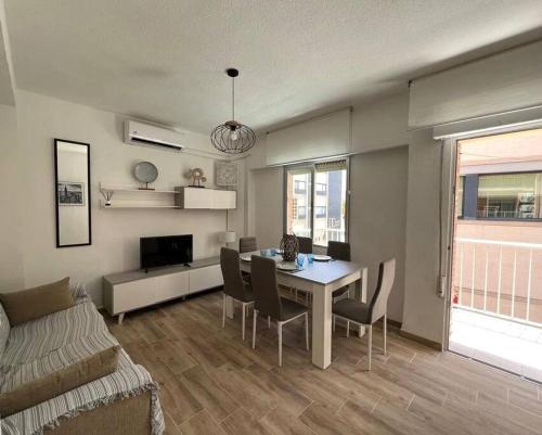salon ze stołem, krzesłami i kanapą w obiekcie Apartamento céntrico y en primera línea de playa w mieście Benidorm