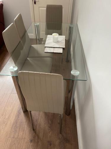 a glass table with a chair and a cup on it at Fife Apartments in Dunfermline