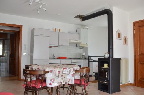 uma cozinha com uma mesa com cadeiras e um fogão em Appartamento Giada Pozzale di Pieve di Cadore(BL) em Pieve di Cadore