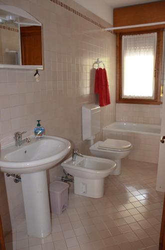 a bathroom with a sink and a toilet and a tub at Appartamento Giada Pozzale di Pieve di Cadore(BL) in Pieve di Cadore