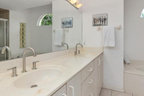 a bathroom with two sinks and a large mirror at Punta Paradise- Enjoy a 4 bedroom pool home in Punta Gorda