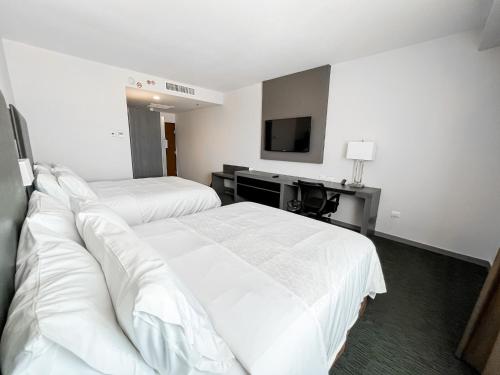 a hotel room with two beds and a television at Holiday Inn Express Hotel & Suites Hermosillo by IHG in Hermosillo