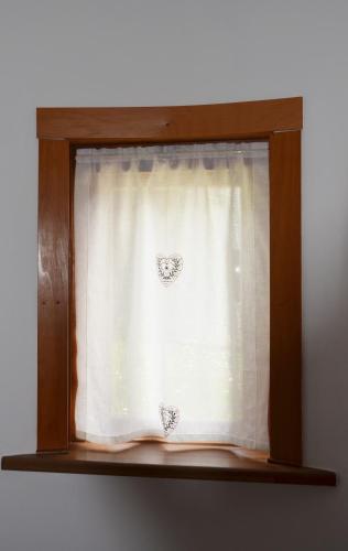 a window with two hearts on the curtain at Appartamento Giada Pozzale di Pieve di Cadore(BL) in Pieve di Cadore