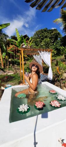 a woman sitting in a pool with an umbrella at La Guarida eco-posada in San Antonio del Tequendama
