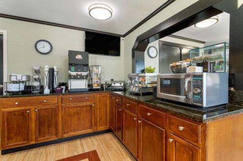 cocina con armarios de madera y encimera con microondas en Best Western Smoky Mountain Inn, en Waynesville