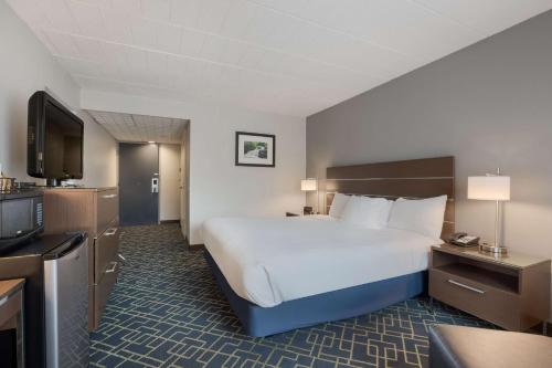 ein Hotelzimmer mit einem Bett und einem Flachbild-TV in der Unterkunft Best Western Hunt's Landing Hotel Matamoras Milford in Matamoras