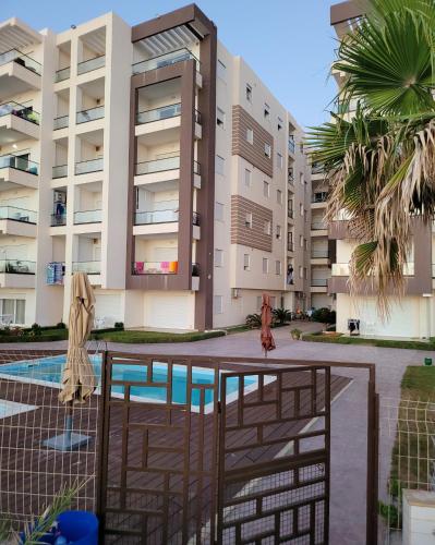 Blick auf ein Gebäude mit Pool in der Unterkunft Résidence Amwej Sousse les pieds dans l'eau in Sousse