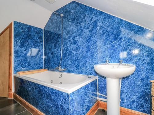 a blue tiled bathroom with a tub and a sink at St Kilda in Balranald