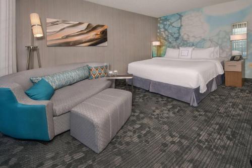 um quarto de hotel com uma cama e um sofá em Sonesta Select Allentown Bethlehem Airport em Allentown