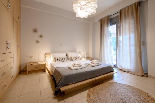 a bedroom with a bed and a large window at Pearl by the sea in Preveza
