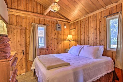a bedroom with a bed in a room with wooden walls at Rustic Suttons Bay Cottage Shared Dock and Fire Pit in Suttons Bay