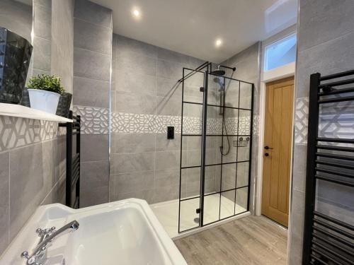 uma casa de banho com um chuveiro e uma banheira em Grisedale Pike em Keswick