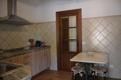 cocina con encimera y mesa con taburetes en Alojamiento Rural Dehesa La Estancia en Andújar