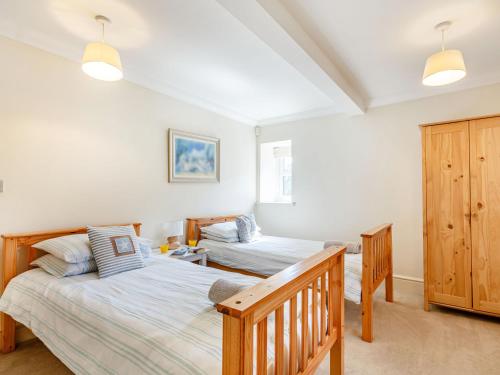 a bedroom with two beds and a crib at Menai View in Llanfairpwllgwyngyll